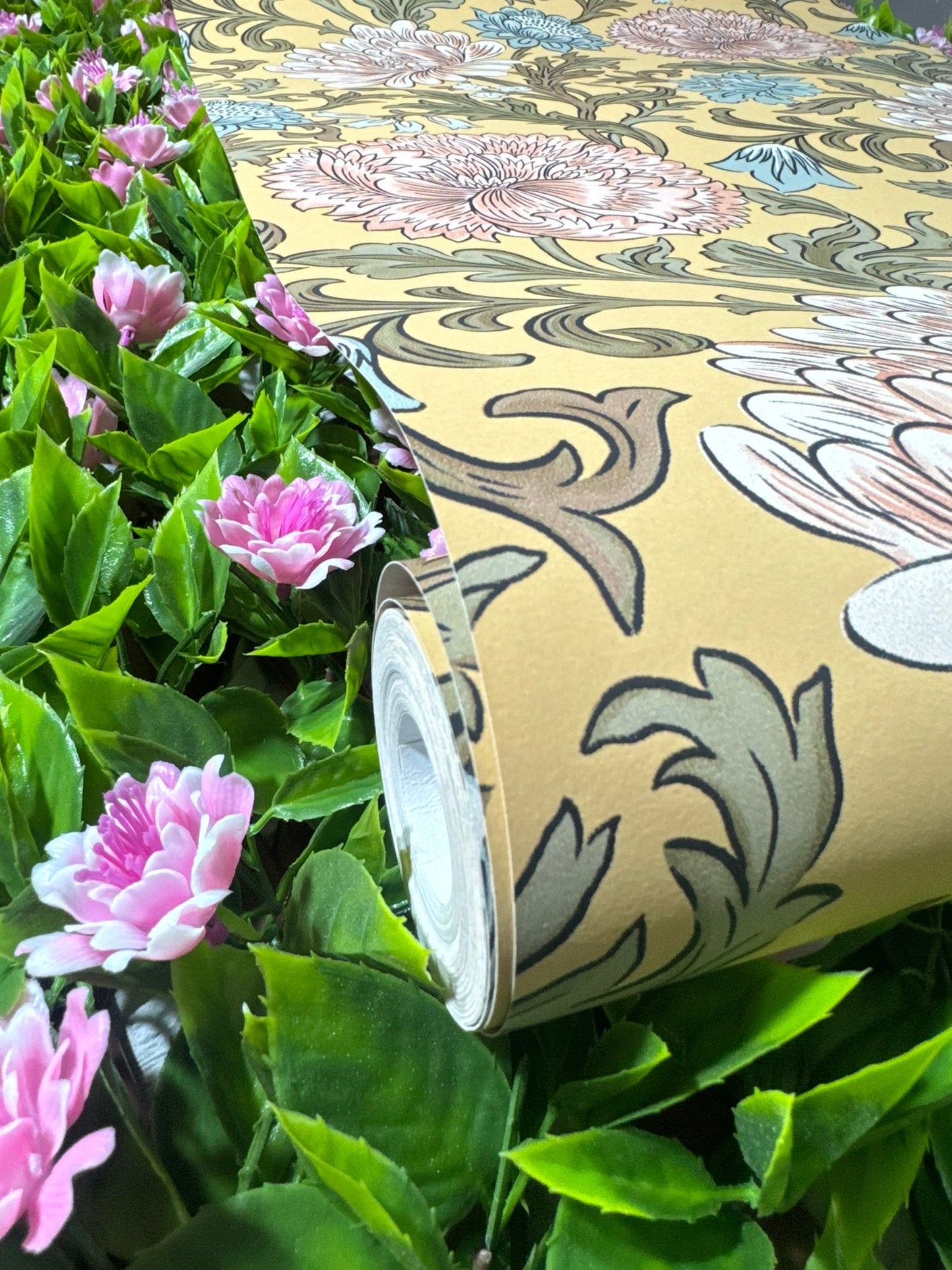 Mustard Floral Wallpaper roll showing chrysanthemum pattern amongst pink garden flowers