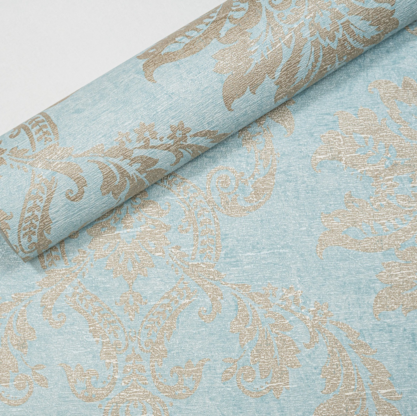 Capri Damask Teal Wallpaper roll close up showing gold damask pattern and teal background